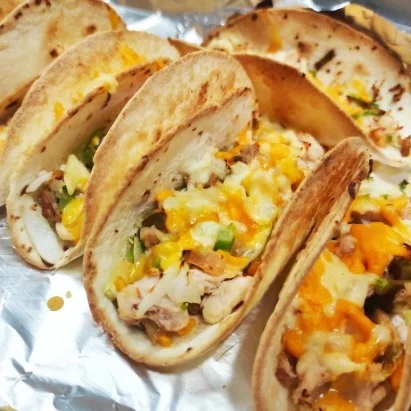 Fajitas de pollo asado con verduras y jalapeños, cubiertas de queso gratinado