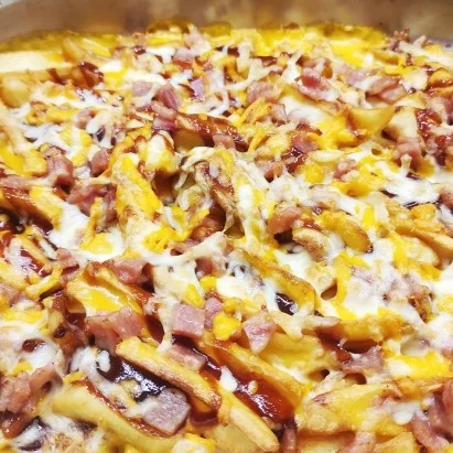 Patatas dipper con salsa cheddar y barbacoa, bacon crispy y tres quesos